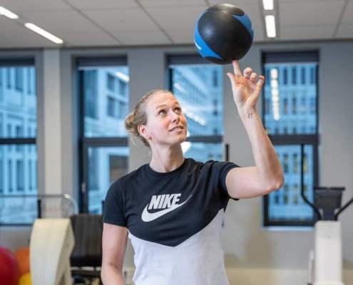 Sports girl in NIKE shirt balancing volley ball on tip of her index finger