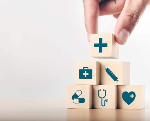 wooden cubes with medical icons getting stacked on top of each other